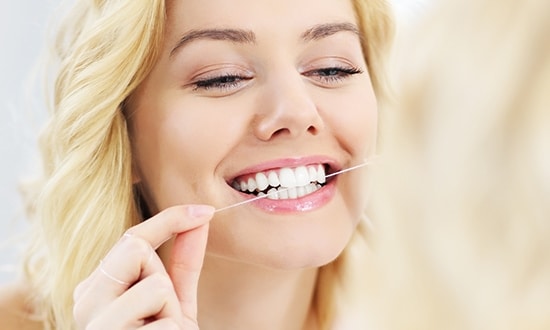 Patient flossing teeth Bristol